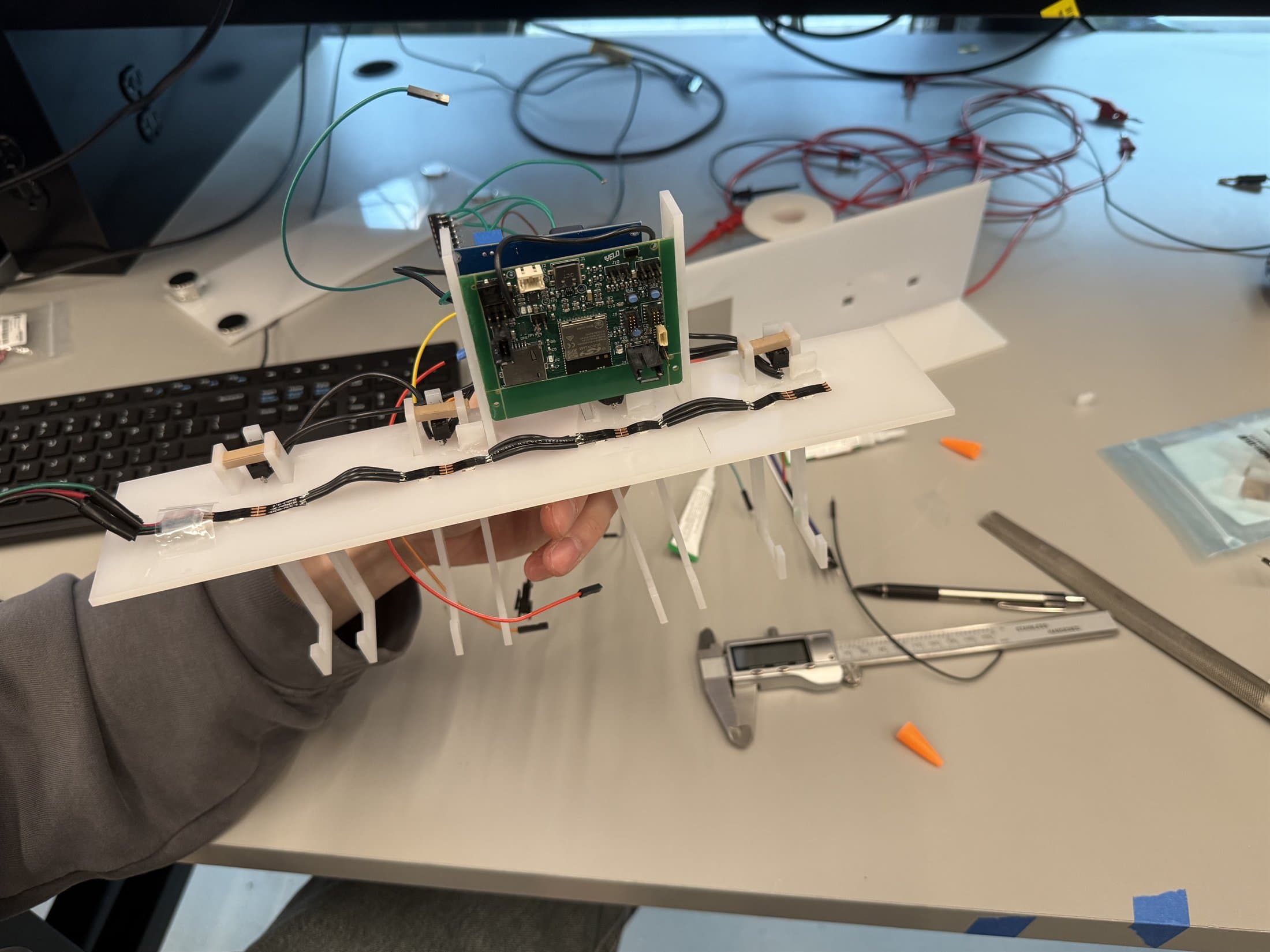 Velo hook base and PCBA photographed from the front during assembly.